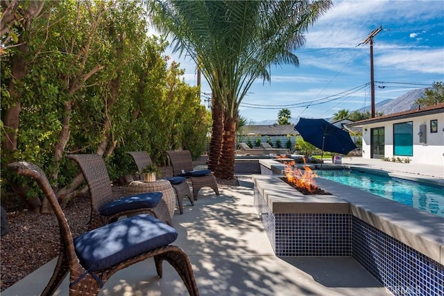 view of pool featuring an outdoor fire pit and a patio