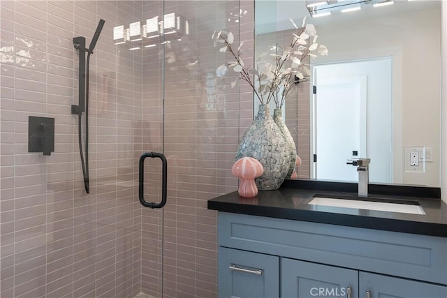 bathroom featuring a shower with door and sink