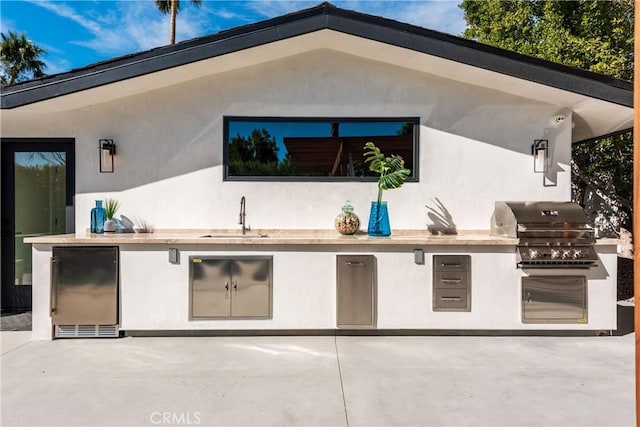 view of patio with area for grilling, sink, and a grill