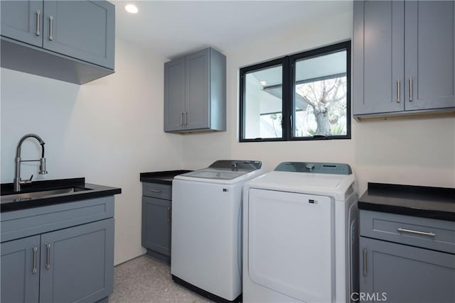 clothes washing area featuring cabinets, separate washer and dryer, and sink