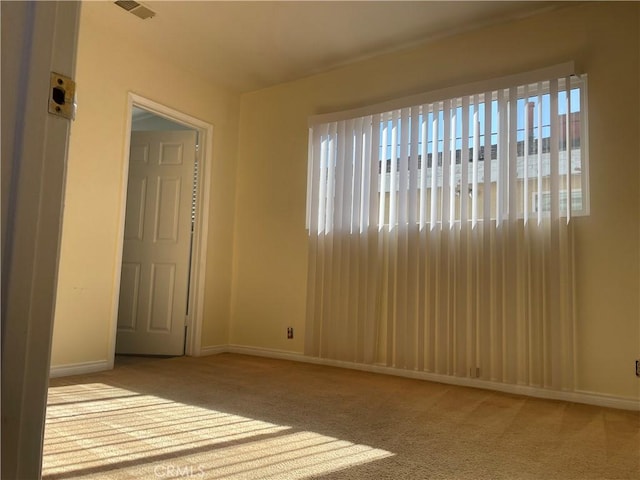 unfurnished room featuring a healthy amount of sunlight and light carpet