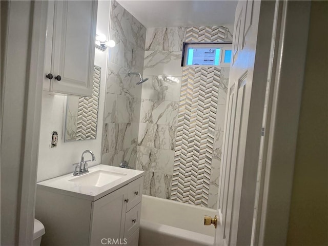 full bathroom with tiled shower / bath, vanity, and toilet