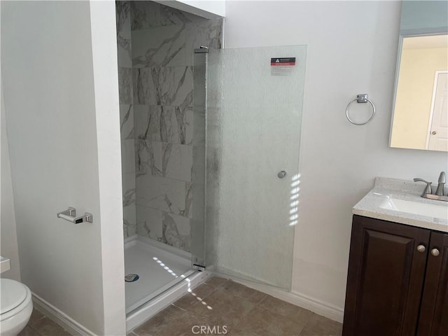 bathroom featuring vanity, tiled shower, and toilet