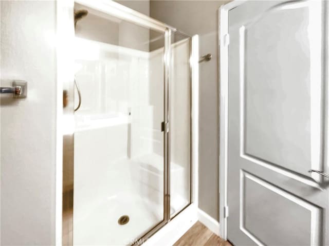 bathroom featuring a shower with shower door and hardwood / wood-style floors