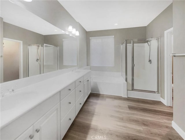 bathroom with vanity, wood-type flooring, and shower with separate bathtub