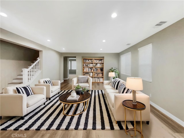 living room featuring built in features and light wood-type flooring