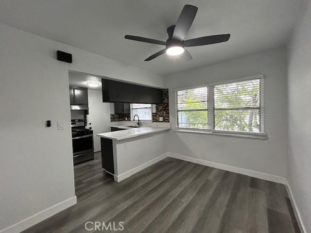 kitchen with sink, backsplash, dark hardwood / wood-style floors, stainless steel electric stove, and kitchen peninsula