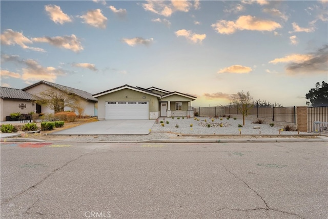 view of front of property featuring driveway, an attached garage, and fence