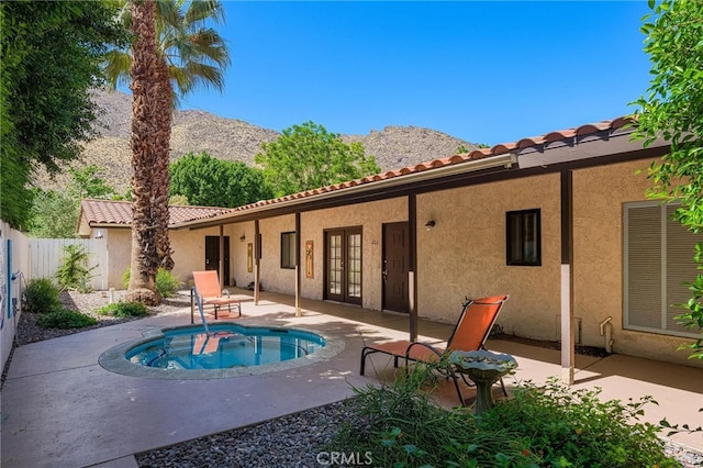 back of house featuring french doors, a mountain view, and a patio area