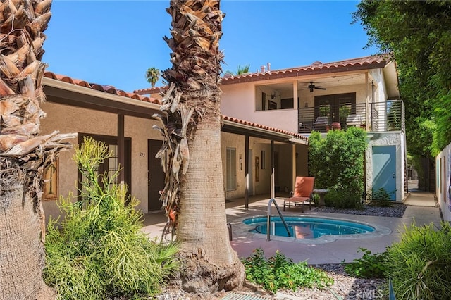 rear view of house with ceiling fan, a patio area, and a balcony