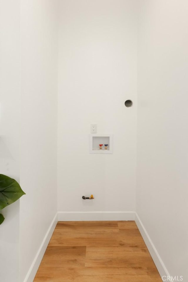 washroom featuring laundry area, baseboards, washer hookup, and wood finished floors