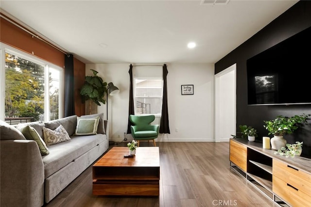 living room featuring recessed lighting, visible vents, baseboards, and wood finished floors