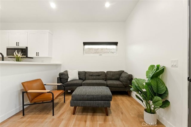 living room with recessed lighting, light wood-style flooring, and baseboards