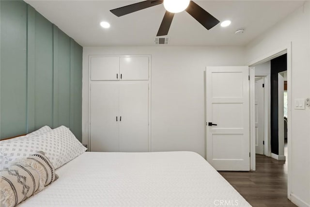 bedroom featuring ceiling fan, recessed lighting, dark wood-type flooring, visible vents, and a closet