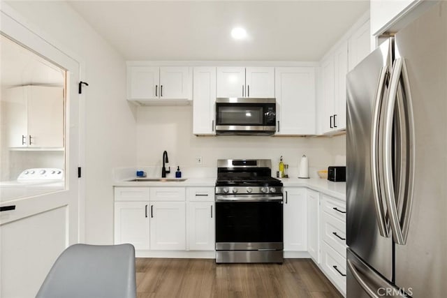 kitchen featuring white cabinetry, stainless steel appliances, a sink, and light countertops