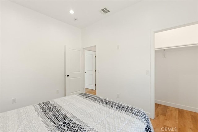 bedroom with recessed lighting, a closet, visible vents, light wood-type flooring, and baseboards