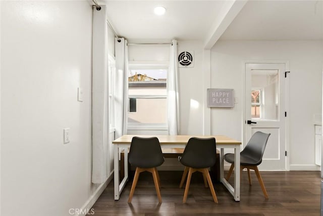 dining room featuring breakfast area, dark wood-style flooring, and baseboards