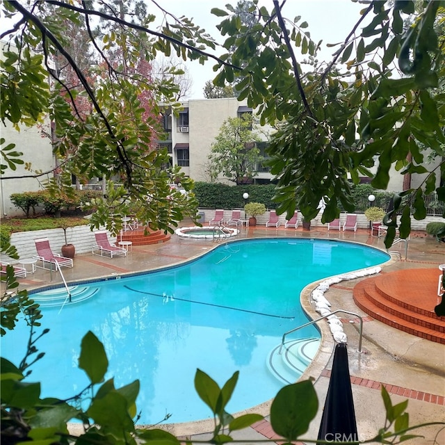 view of pool with a patio and a hot tub