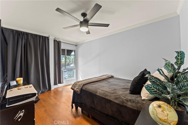 bedroom with hardwood / wood-style floors, ceiling fan, and crown molding