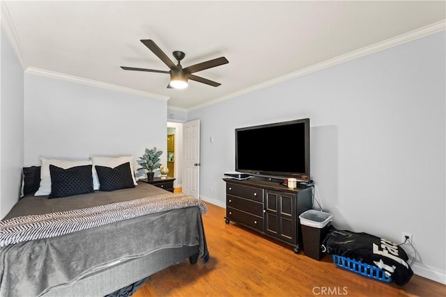 bedroom featuring hardwood / wood-style flooring, ceiling fan, and ornamental molding