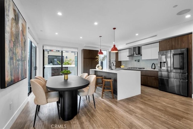 dining space with light hardwood / wood-style floors and sink