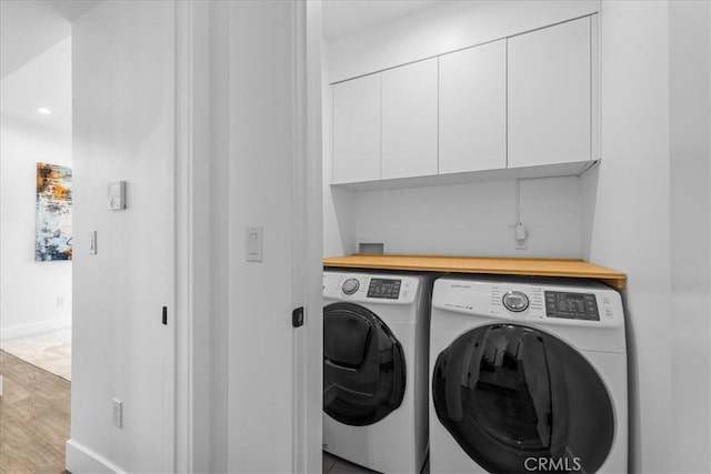 1304 N Mansfield Ave, Los Angeles, CA 90028 - washroom with washing machine and clothes dryer, cabinet space, wood finished floors, and baseboards