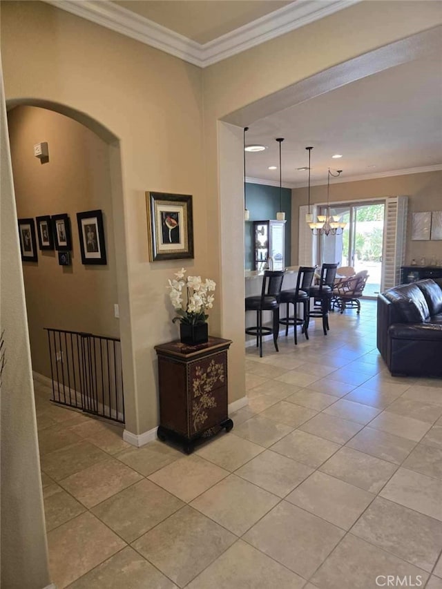 hallway with light tile patterned floors, crown molding, and a chandelier