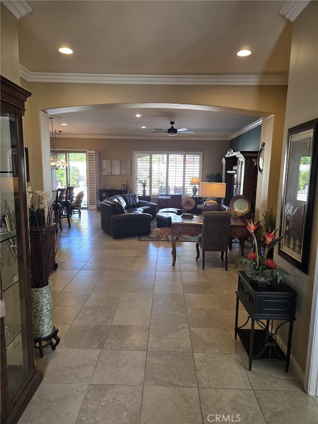 tiled living room with ornamental molding and ceiling fan