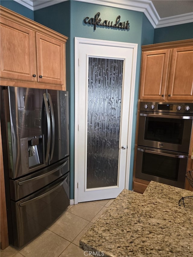 kitchen featuring ornamental molding, light stone counters, double oven, and black refrigerator with ice dispenser