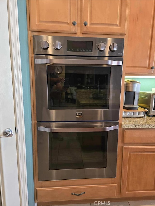 interior details with stainless steel double oven and light stone counters