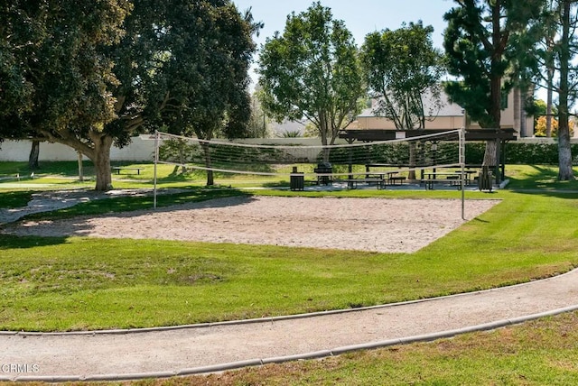 view of community with volleyball court and a lawn