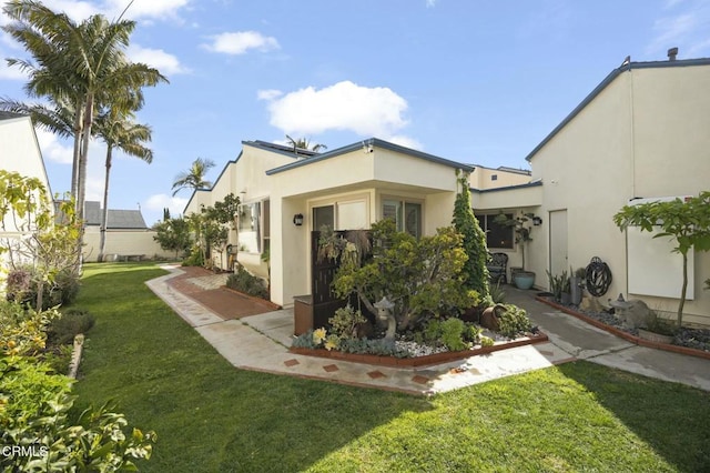 back of property featuring a yard and a patio