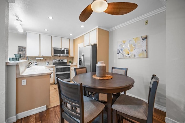 dining room with crown molding, sink, and ceiling fan