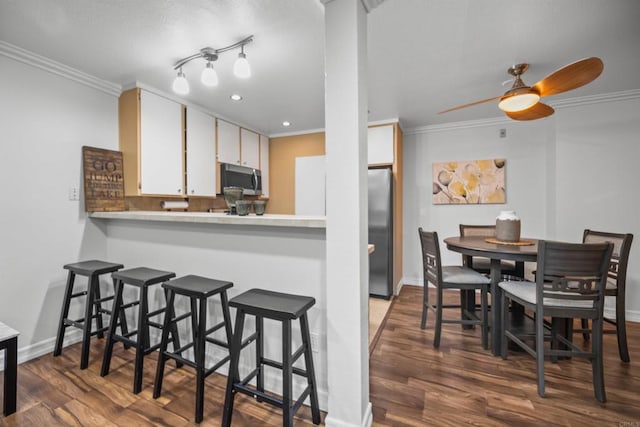 kitchen with crown molding, stainless steel appliances, dark hardwood / wood-style floors, and white cabinets