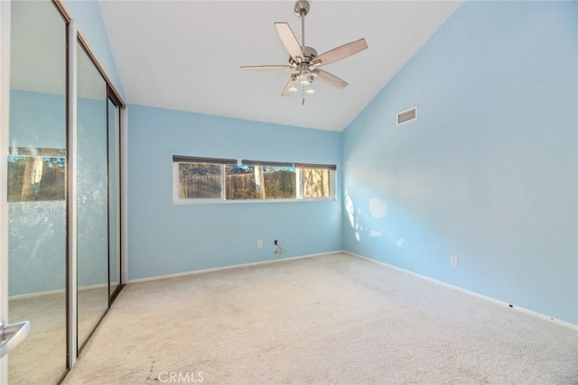 unfurnished bedroom with high vaulted ceiling, light colored carpet, ceiling fan, and a closet