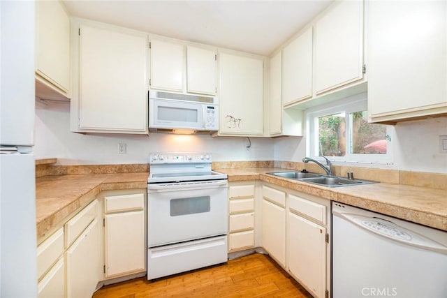 kitchen with sink, white cabinets, white appliances, and light hardwood / wood-style floors