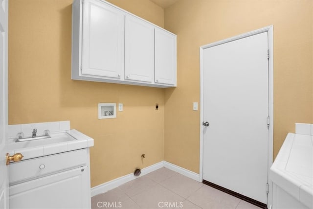 washroom with sink, electric dryer hookup, cabinets, washer hookup, and light tile patterned flooring