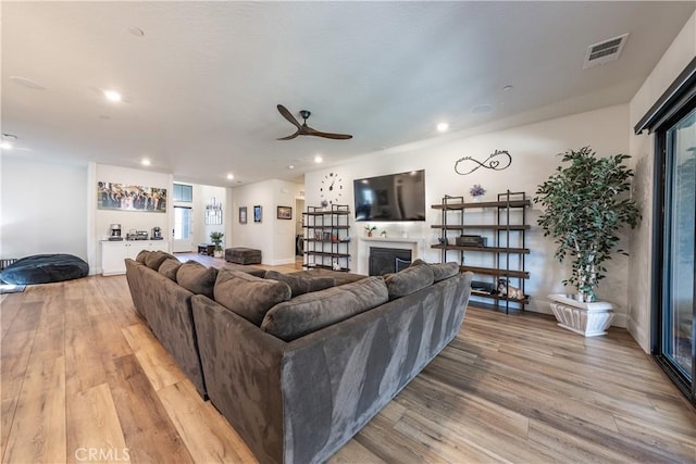 living room featuring light hardwood / wood-style flooring and ceiling fan