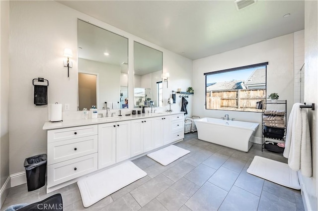 bathroom with vanity, a bathing tub, and tile patterned floors