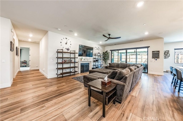 living room featuring light hardwood / wood-style floors and ceiling fan