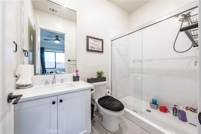 bathroom featuring toilet, vanity, a shower with door, ceiling fan, and tile patterned flooring