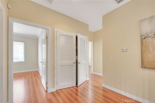 hall with crown molding and light hardwood / wood-style floors