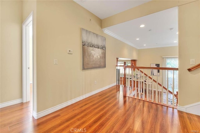 hallway with hardwood / wood-style flooring and ornamental molding