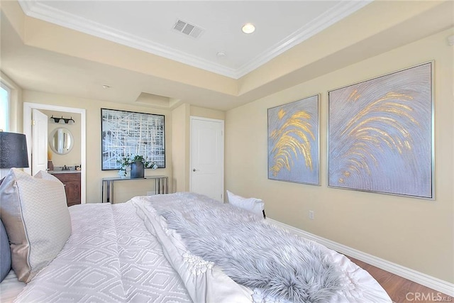 bedroom featuring crown molding, wood-type flooring, and a raised ceiling