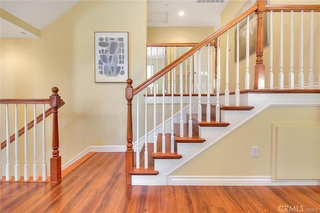 staircase with hardwood / wood-style floors