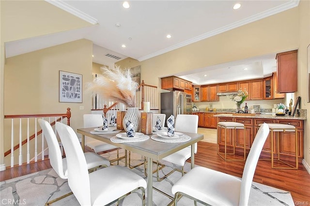 dining space featuring ornamental molding and light wood-type flooring