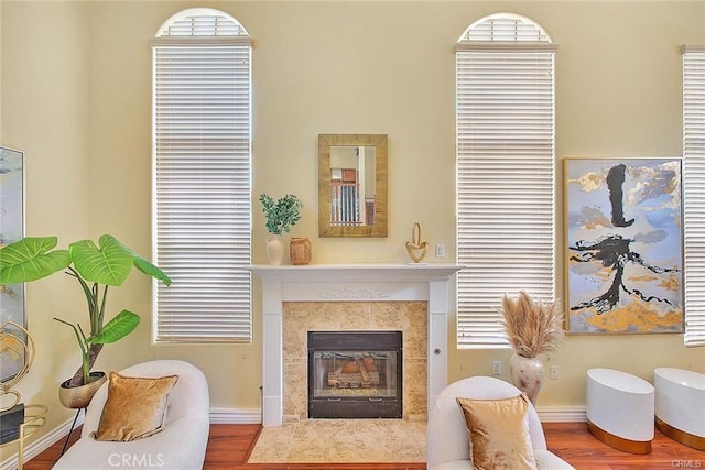 sitting room with wood-type flooring and a tiled fireplace