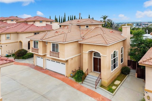 mediterranean / spanish-style home featuring a tile roof, driveway, fence, a garage, and stucco siding