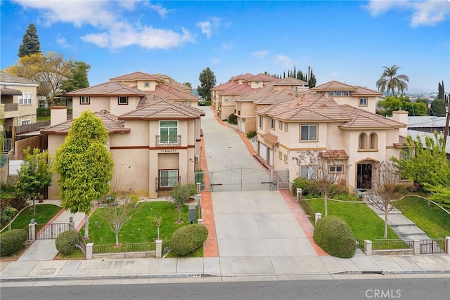 mediterranean / spanish-style house featuring a gate, a residential view, concrete driveway, stucco siding, and fence private yard