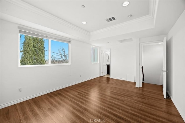 unfurnished bedroom with a tray ceiling, visible vents, recessed lighting, wood finished floors, and crown molding